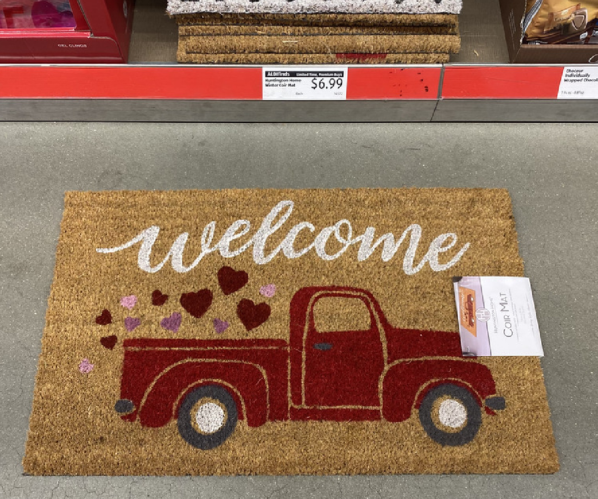 coir welcome rug showing a red truck and hearts laying on an aldi store floor