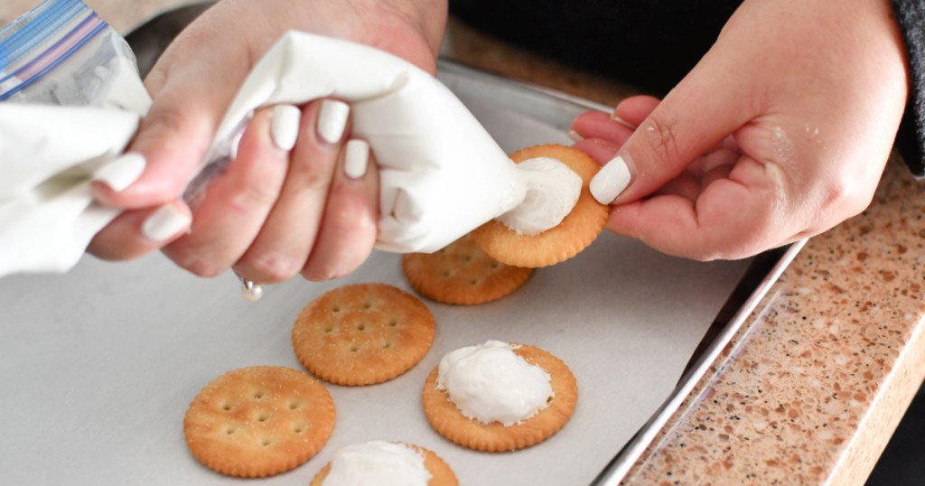 adding marshmallow cream to ritz peanut butter cracker sandwich