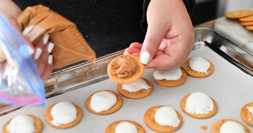 adding peanut butter to ritz cracker