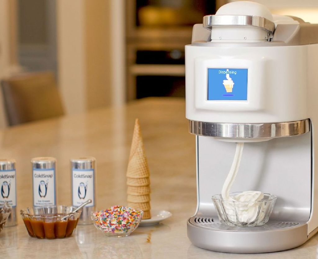 ice cream machine next to cones and toppings