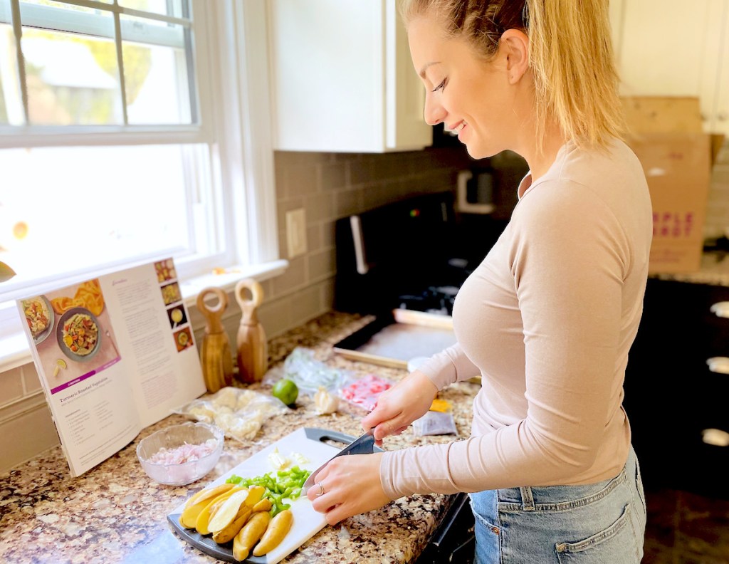 woman chopping food on cutting board