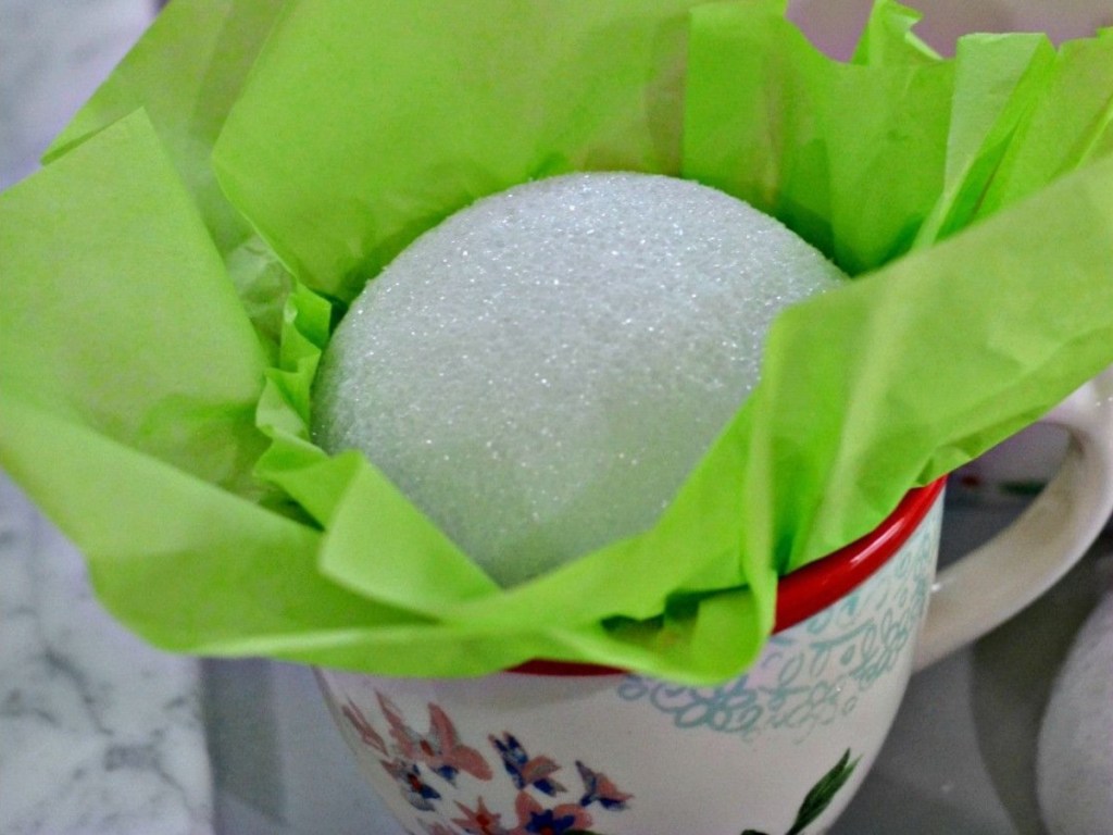 foam ball and green tissue paper in coffee mug