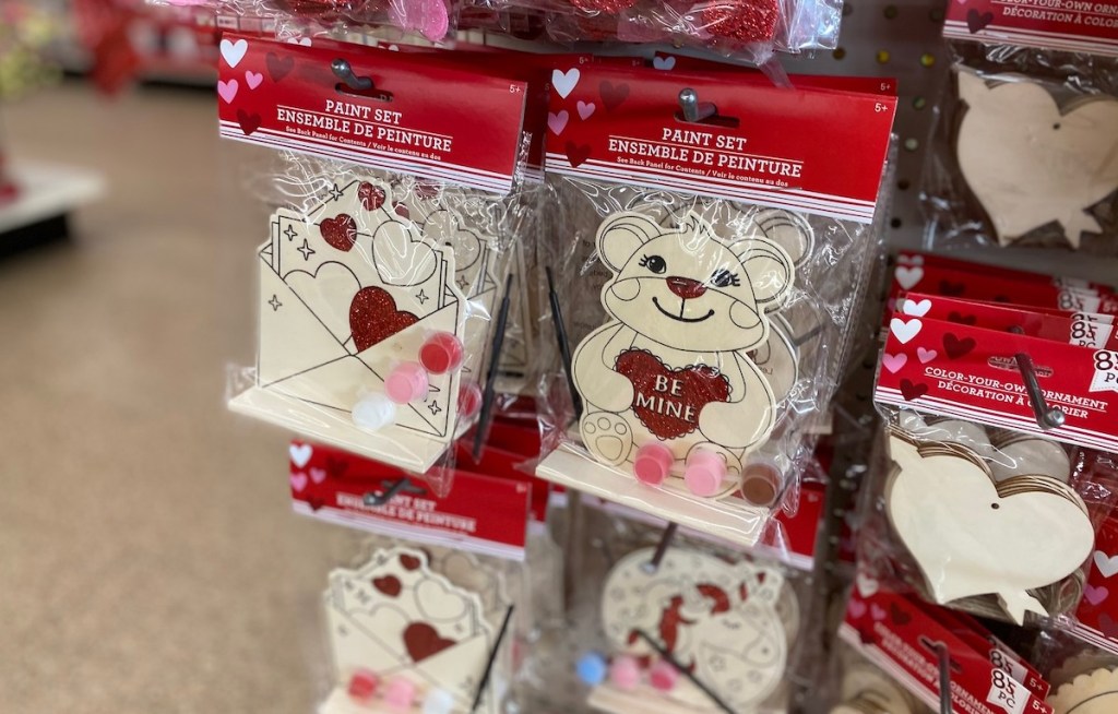 wood and glitter dollar tree valentines craft kits hanging on shelf