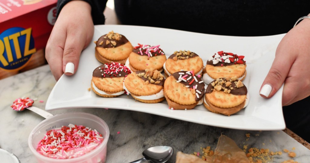 holding a tray of chocolate-dipped ritz crackers