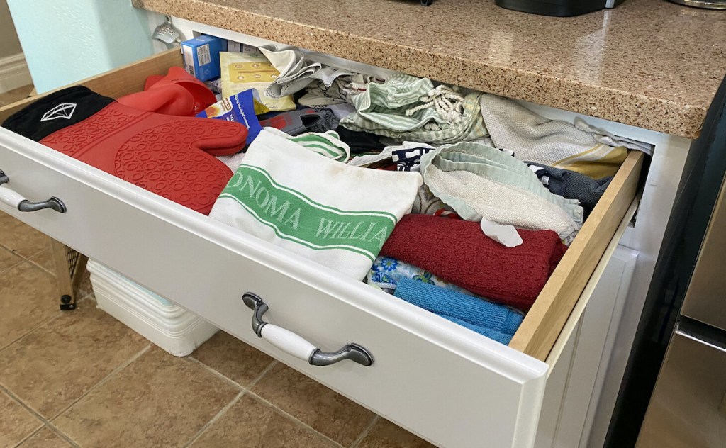 open kitchen junk drawer with various messy stuff inside