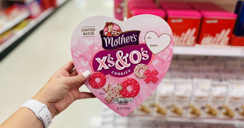 holding heart-shaped box of cookies