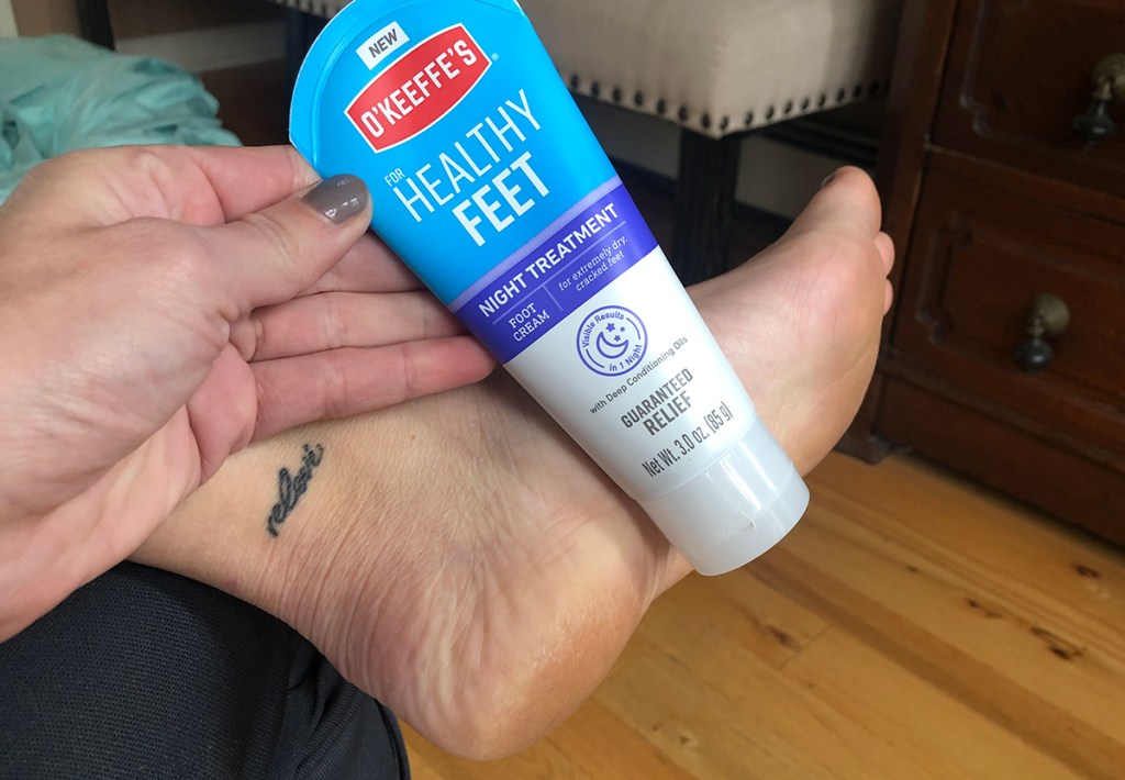 holding o'keefe's foot cream with dry heel