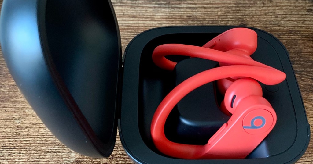 Pair of lava red wireless beats in black case on wooden table