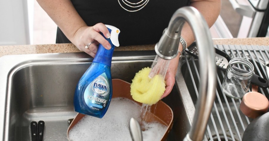 woman washing dishes over the sink with dawn power wash