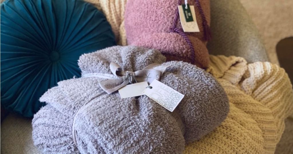 Barefoot Dreams blankets and pillows on a couch