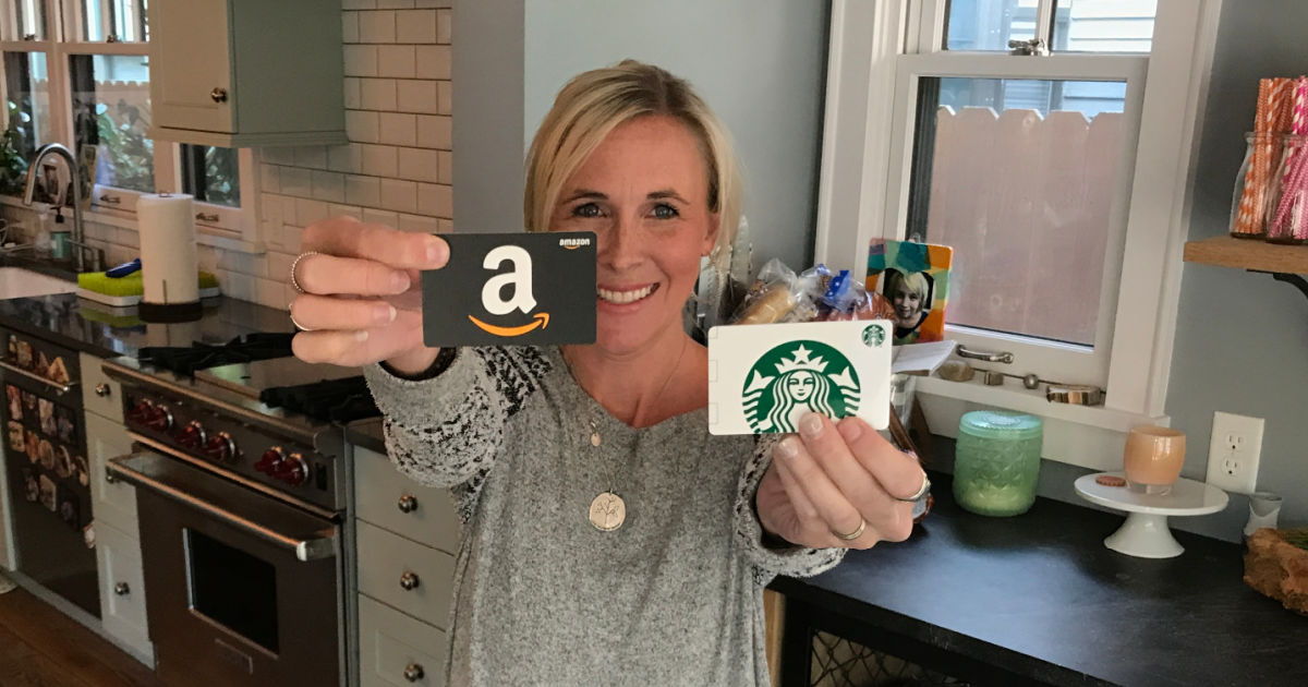 woman holding starbucks and amazon gift cards in kitchen