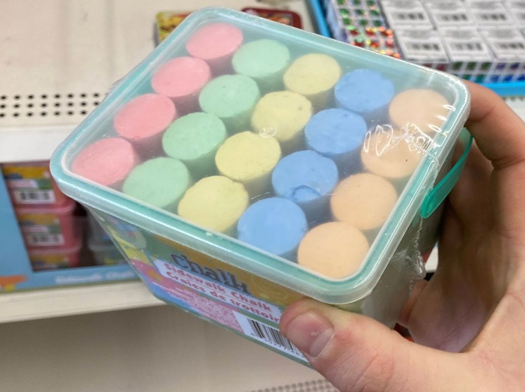 person holding up container of sidewalk chalk