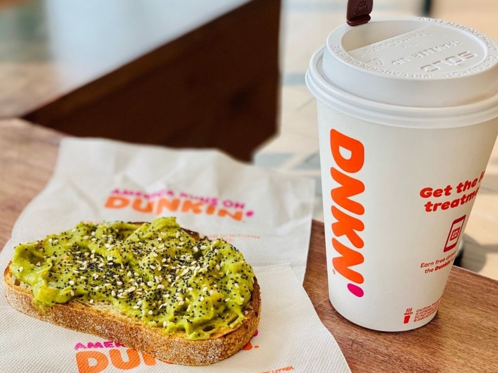 Dunkin avocado toast on a napkin next to a Dunkin hot beverage