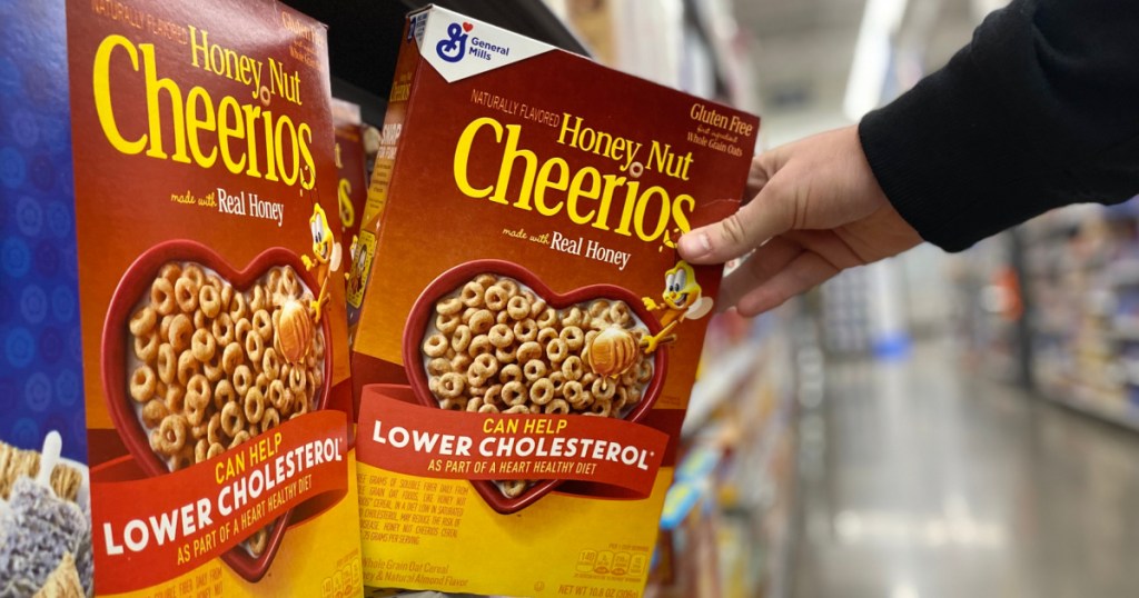 Man's hand grabbing a box of Cheerios