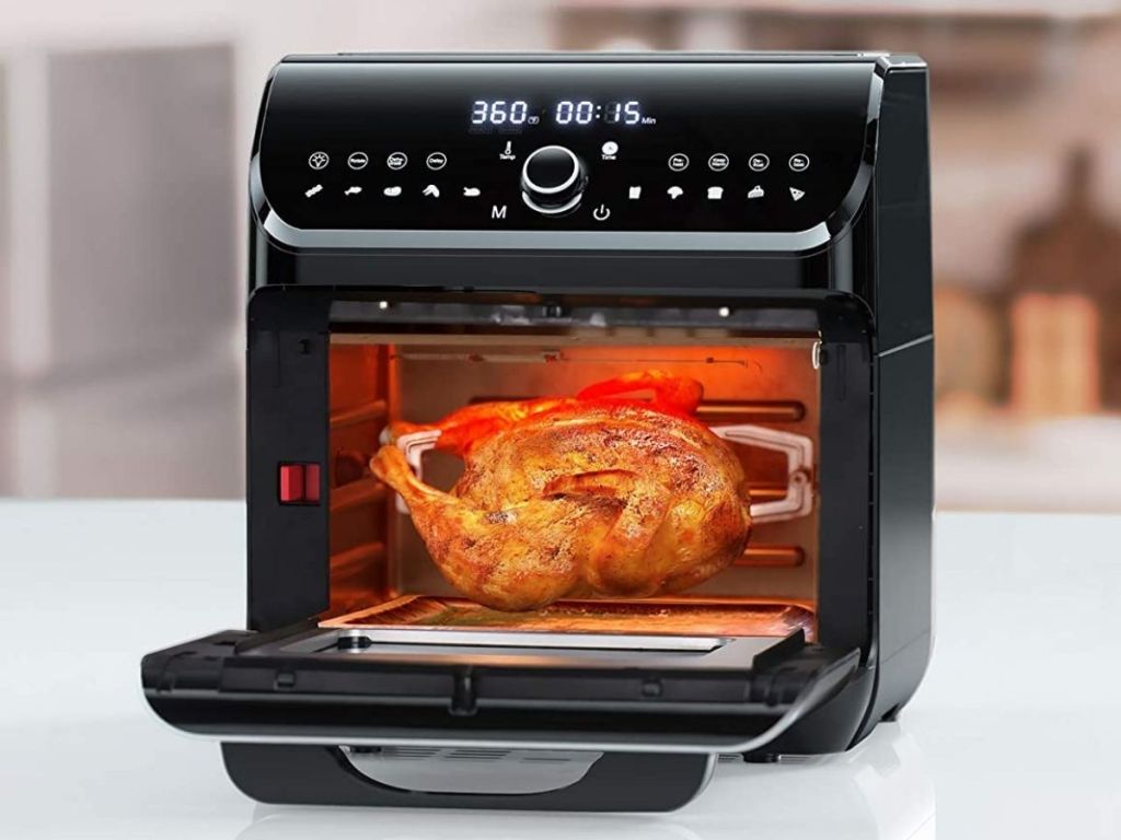 black air fryer oven opened showing chicken on rotisserie 