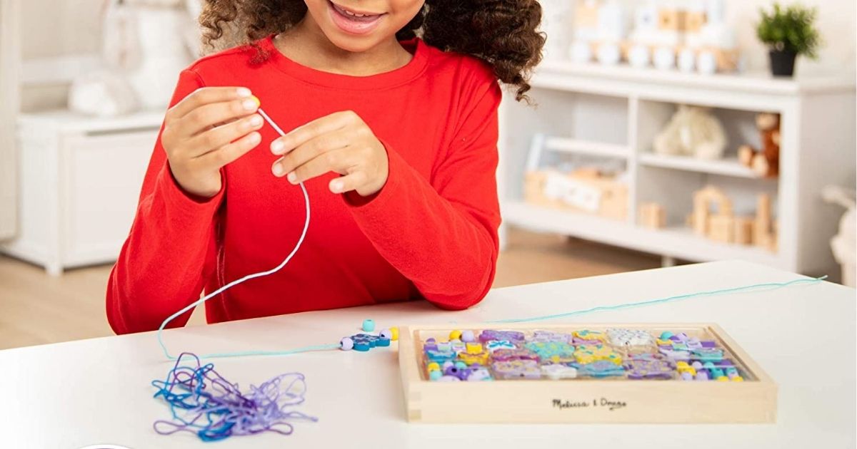 girl playing with Melissa & Doug Wooden Bead Kit