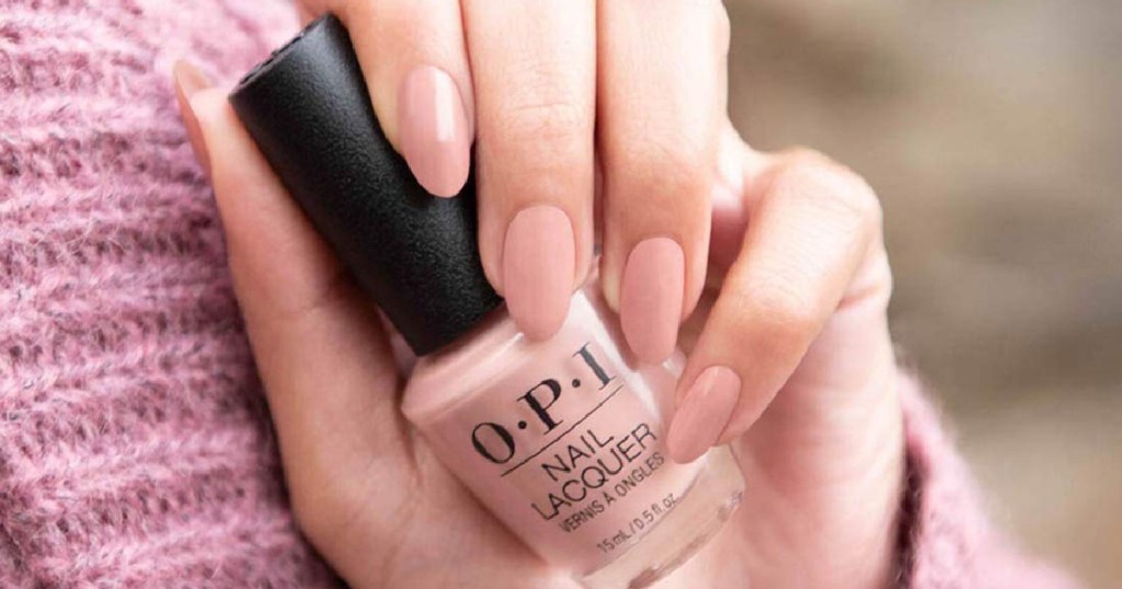hand holding OPI nail polish pink