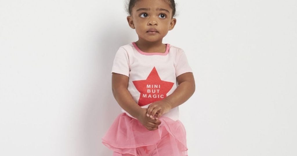 little girl wearing a pink shirt and tutu