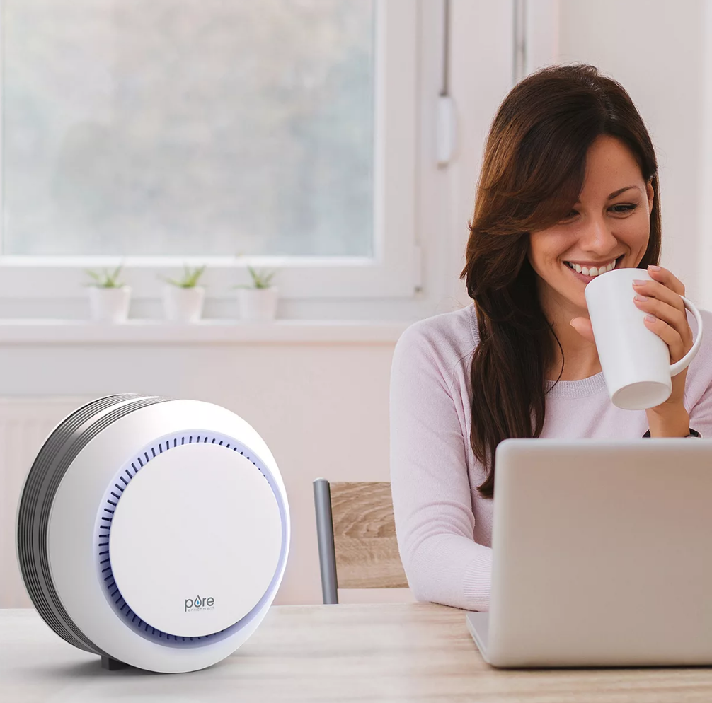 woman sitting next to air purifier