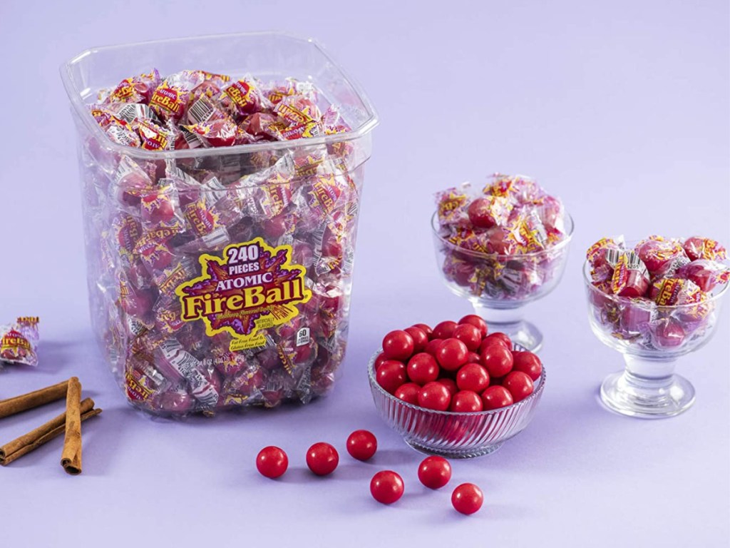 big plastic bin full of candy next to candy dishes