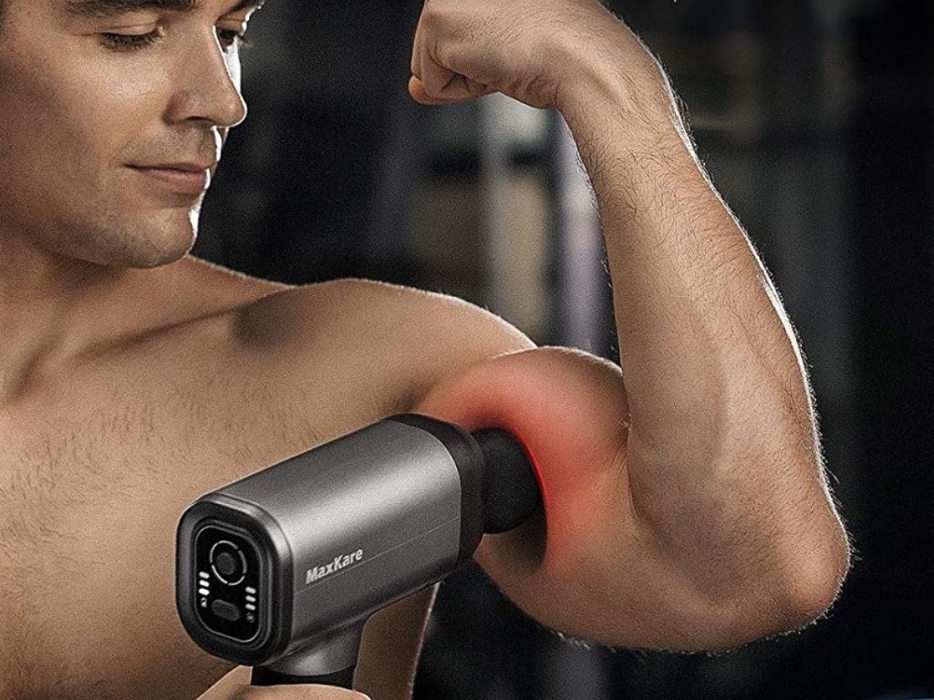 man using massage gun on bicep