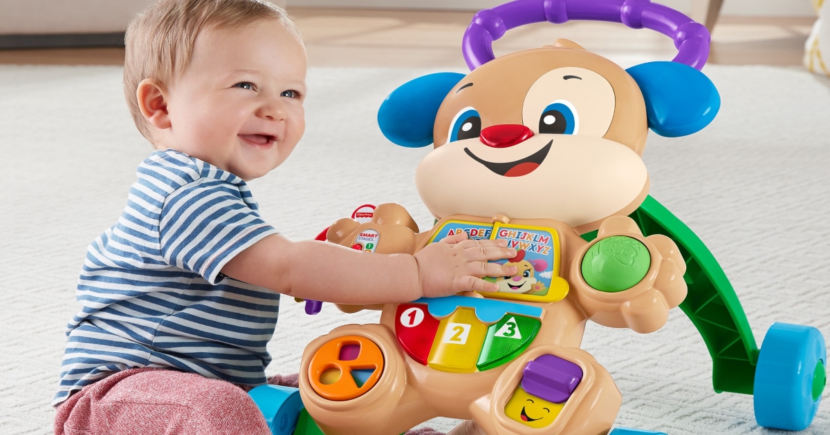 toddler sitting on the floor playing with the toys on the front of the Fisher Price Walker