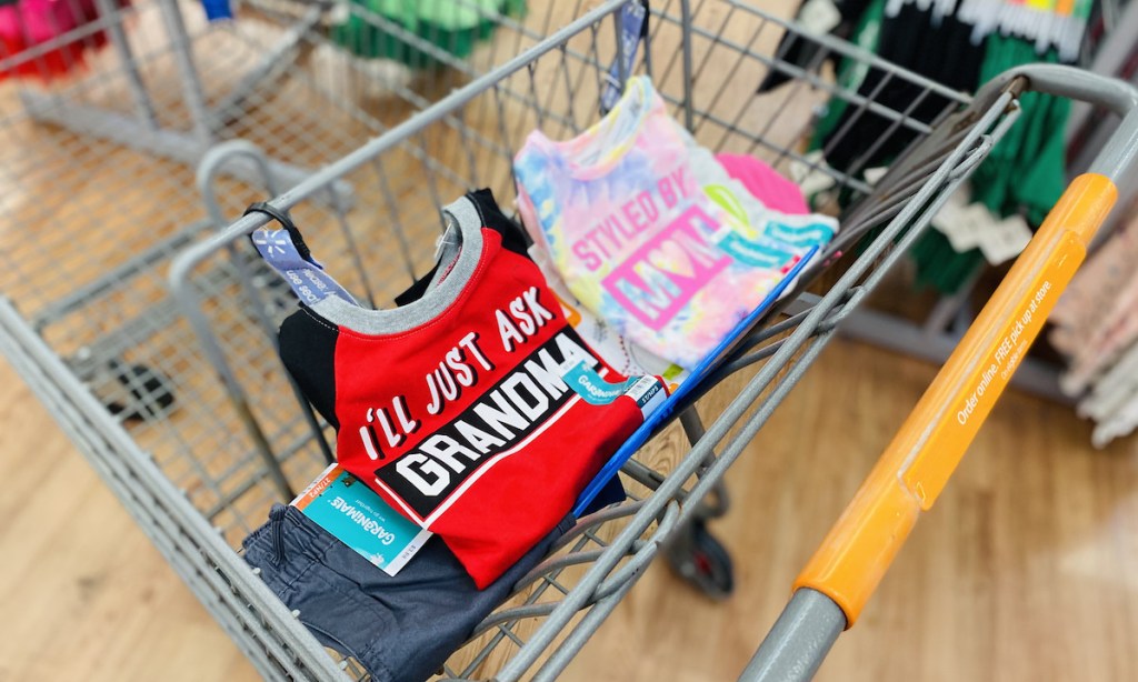 pile of colorful kids clothes sitting in top of store cart