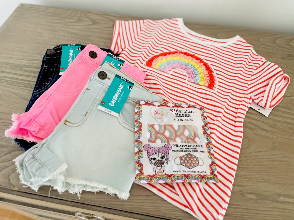 kids rainbow shirt and 3 pairs of shorts on top of wood dresser