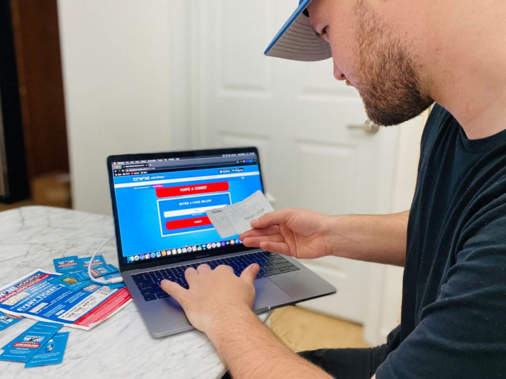 Man entering Albertsons Monopoly Game tickets into computer screen