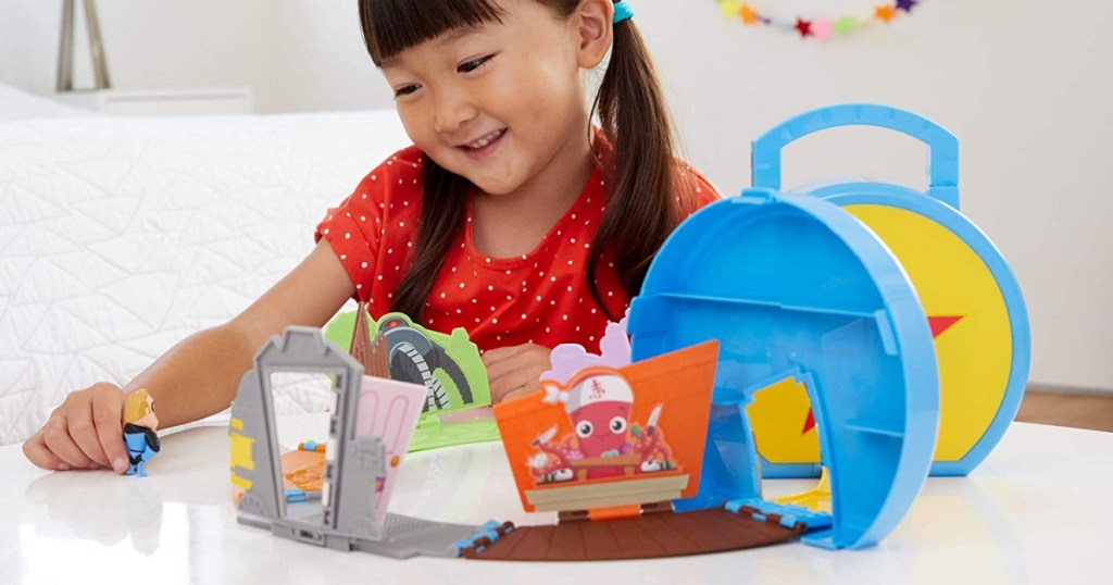 girl playing with Disney mini playset on table
