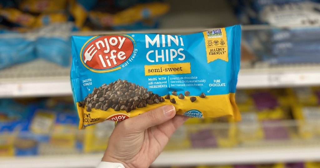 woman's hand holding bag of chocolate chips in store