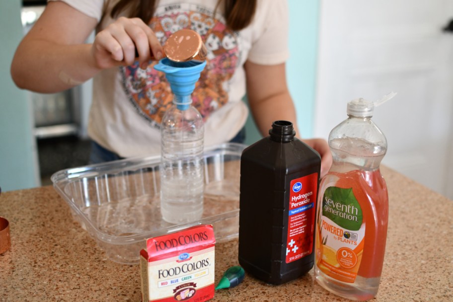 Girl demonstrating how to make elephant toothpaste, an easy diy science project to do at home with the kids