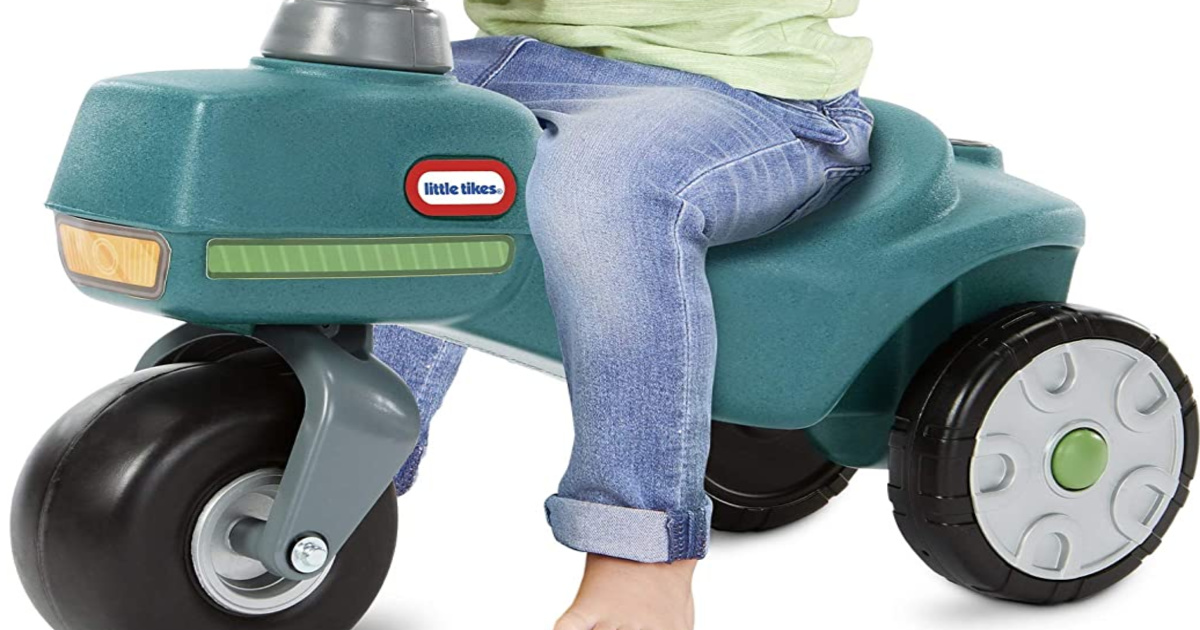 close up of child riding a little tikes tractor toy