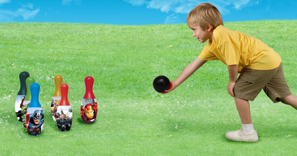 little boy bowling with an Avengers bowling set 