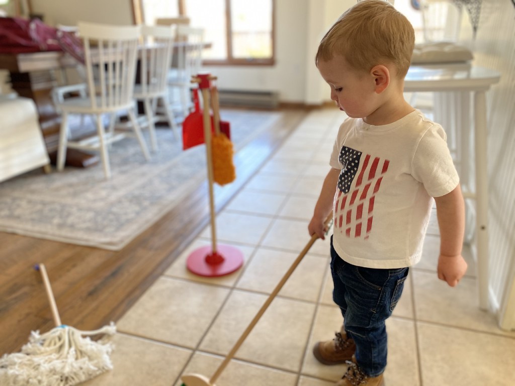 Boy mopping with Melissa & Doug playset