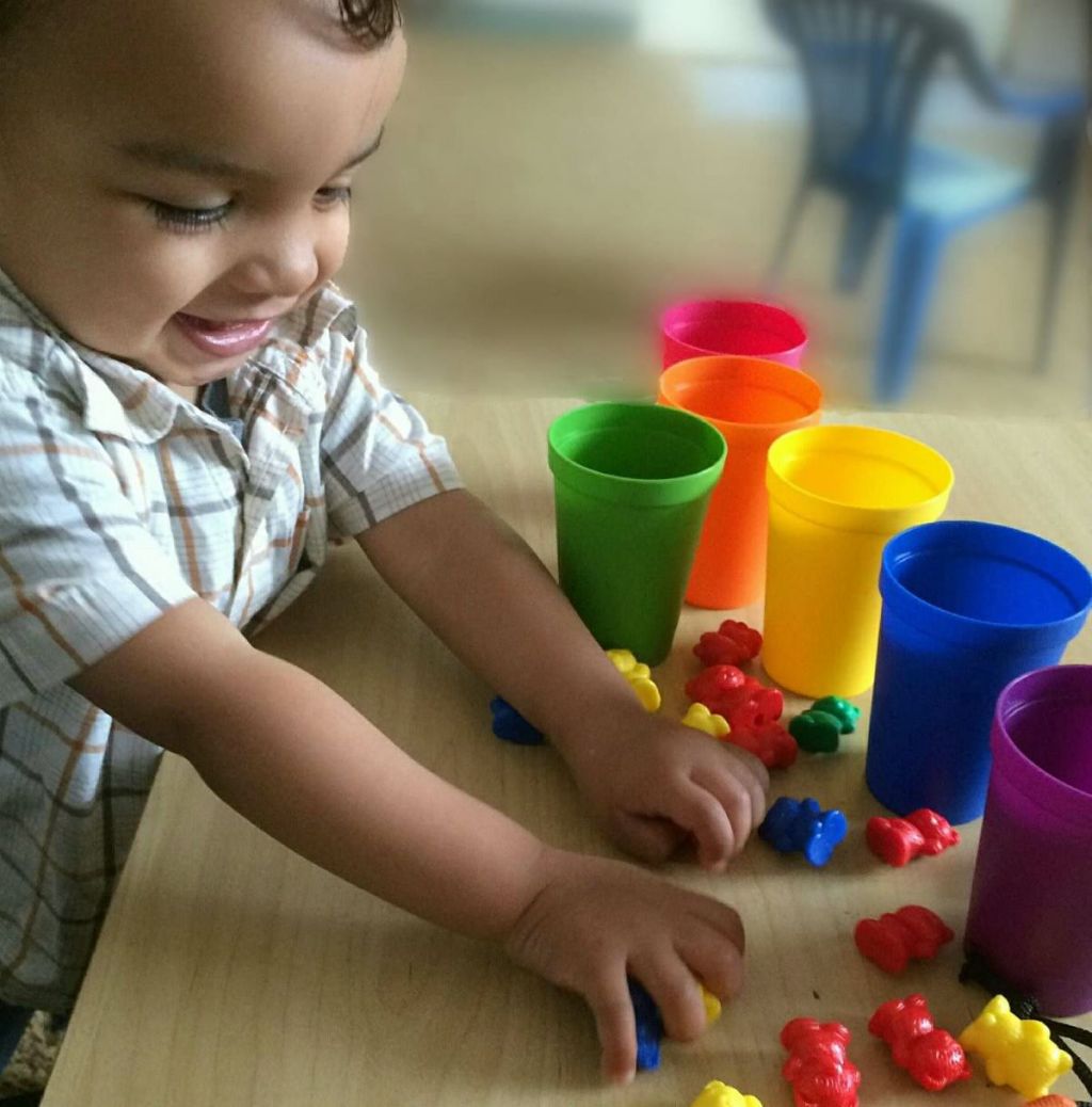 boy playing with colorful bears