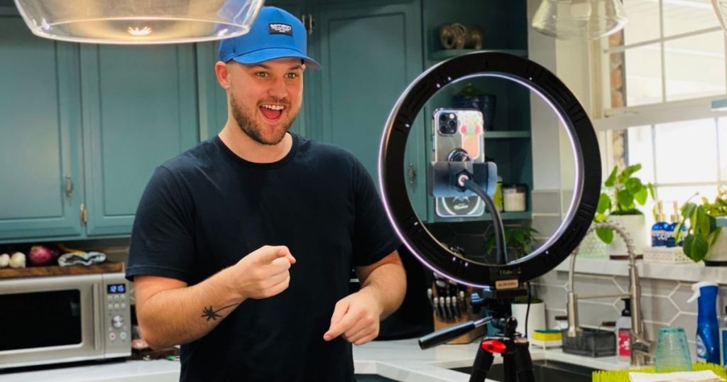 man talking to camera phone placed inside ring light