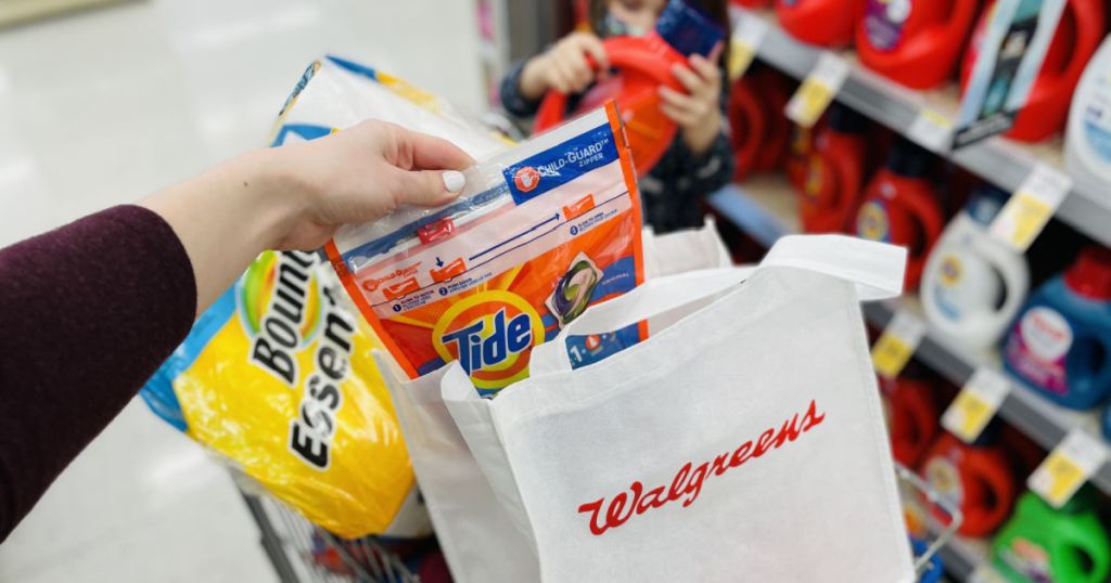 Woman placing Tide detergent into Walgreens bag