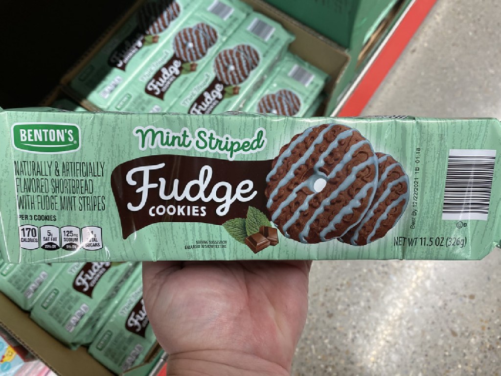 hand holding package of cookies by store display