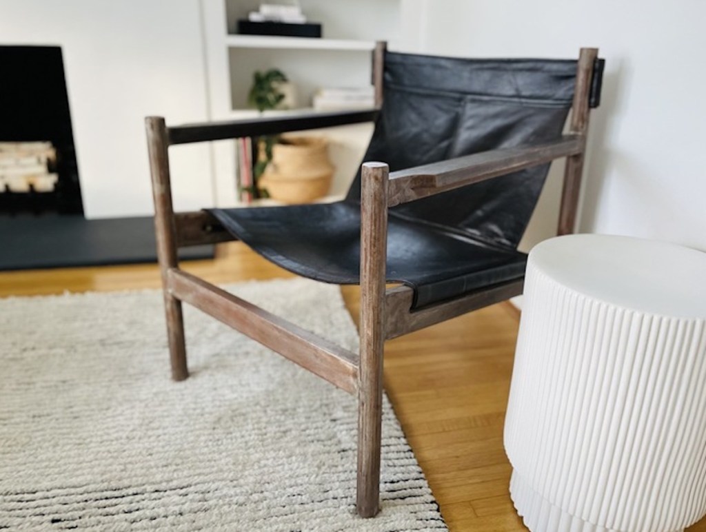 modern leather sling chair sitting in living room with white side table