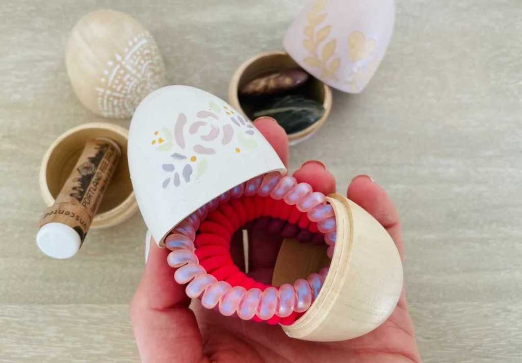 hand holding easter egg with hair ties inside easter basket ideas