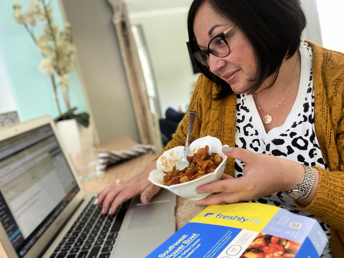 eating a freshly fit lunch at the computer- home delivery meals 