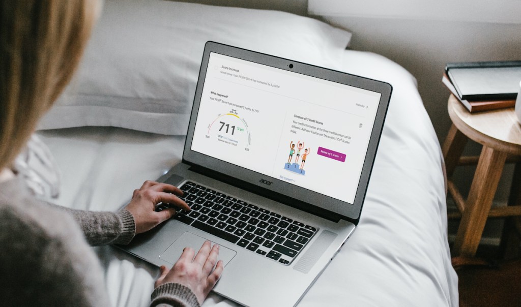 woman typing on laptop with experian boost on screen