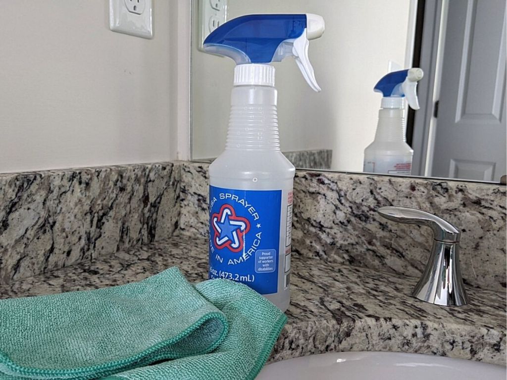 spray bottle and green cloth on granite counters