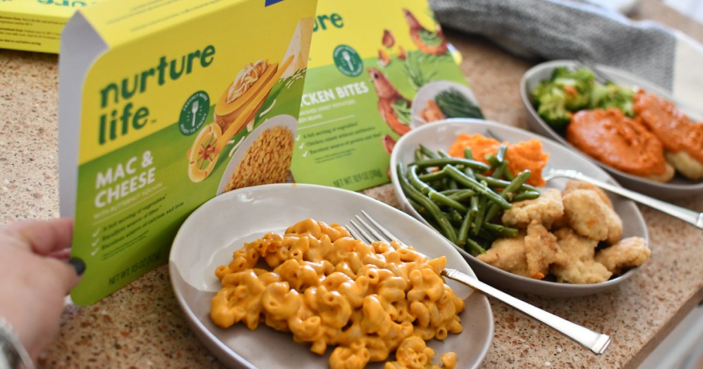 woman holding meal packaging next to macaroni and cheese and other plated meals