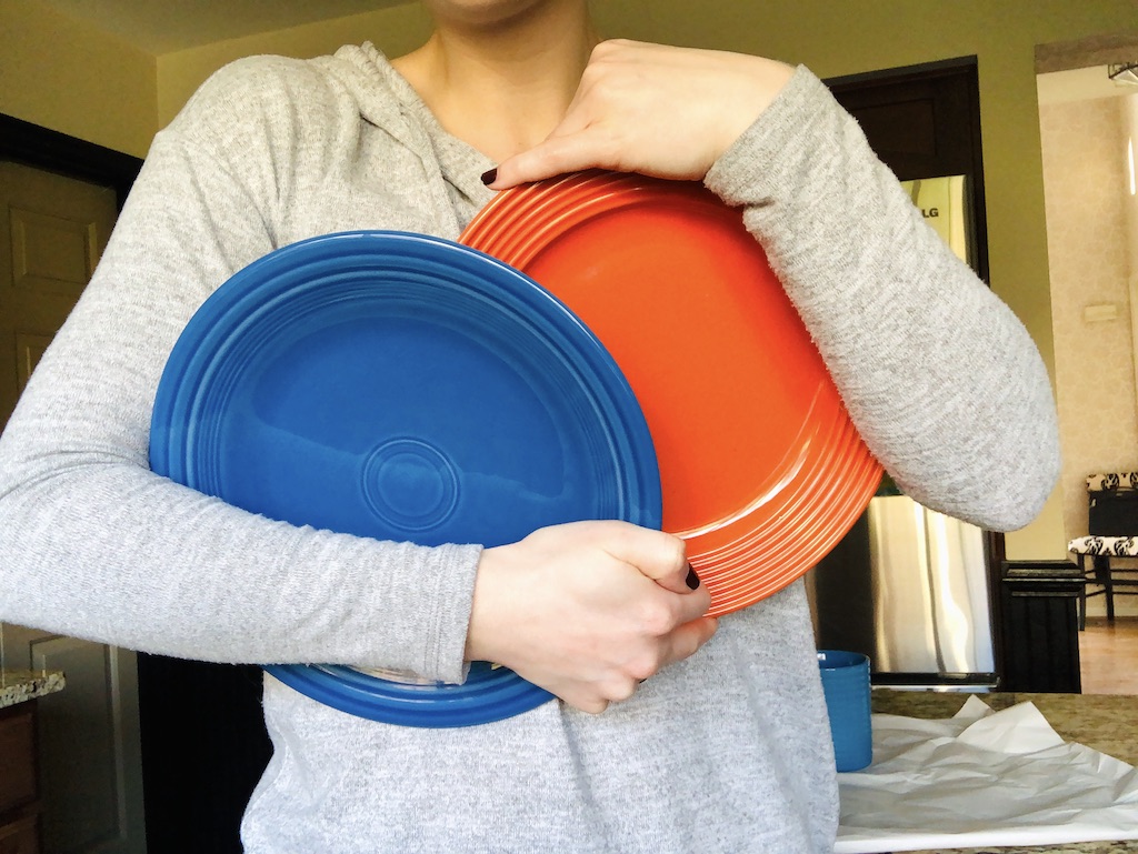 woman holding Dollar Tree plates in kitchen