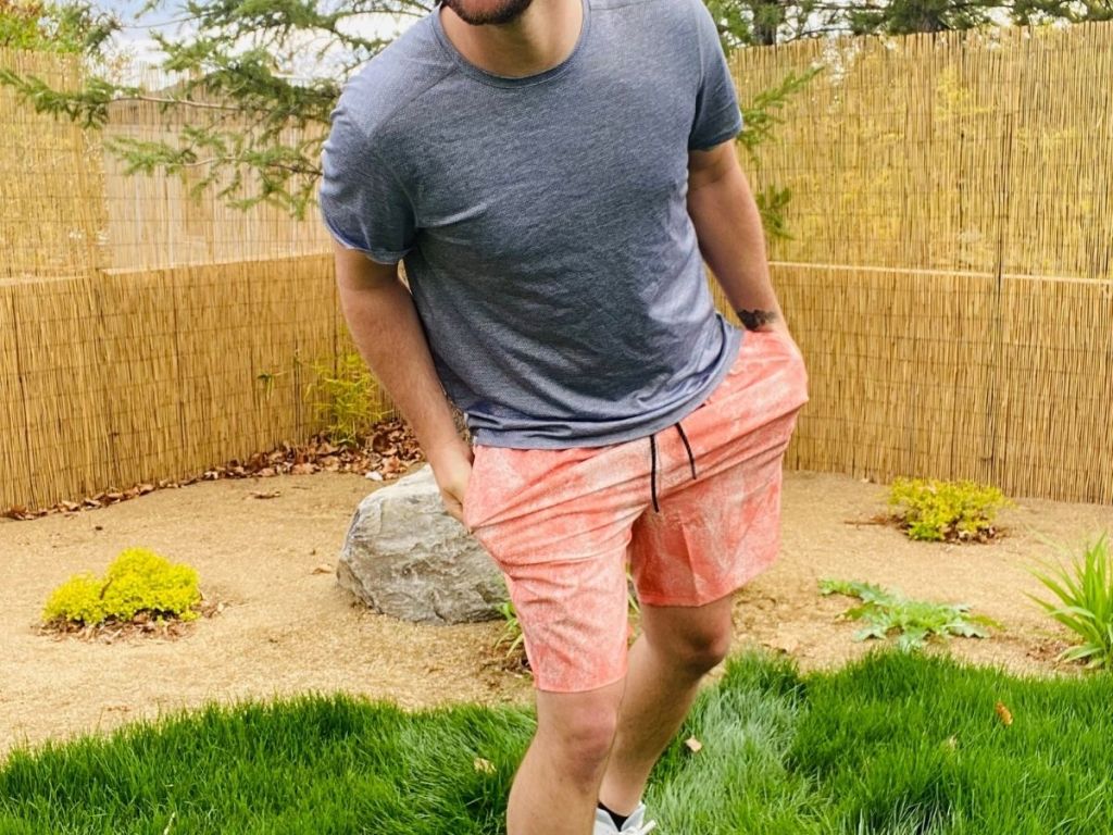 man wearing blue tee and orange and white shorts