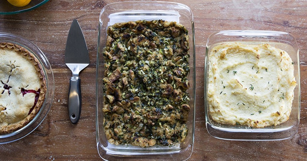 three baking dishes filled with food and pie server on table