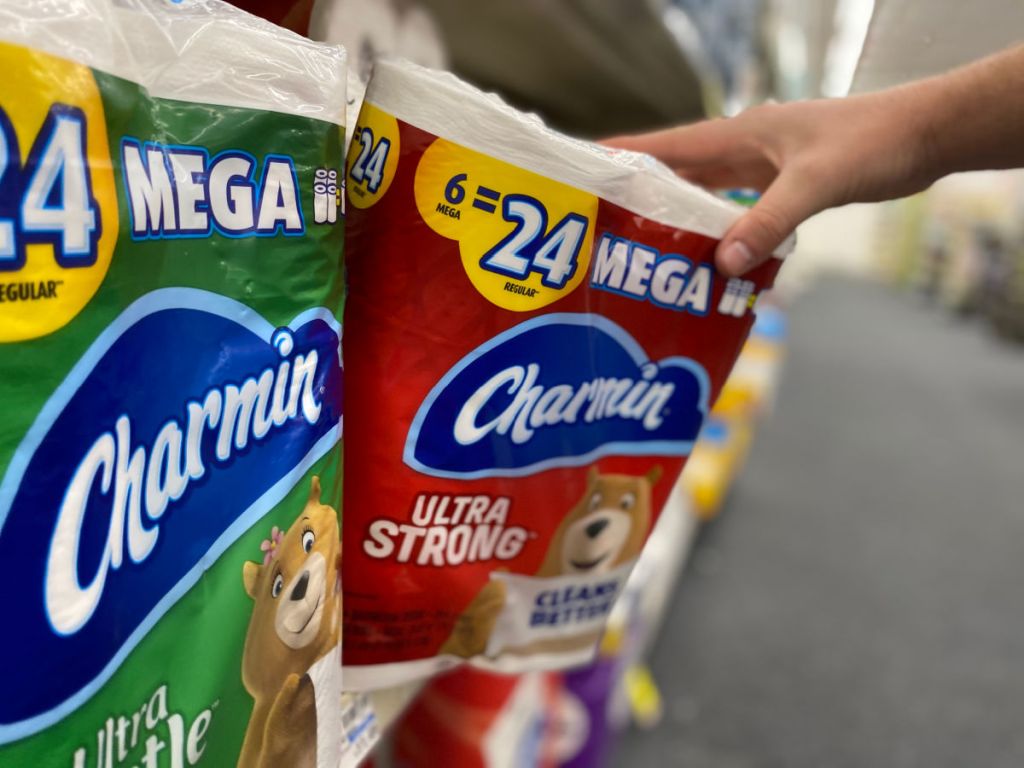 Person grabbing package of Charmin 6 Mega Rolls from store shelf