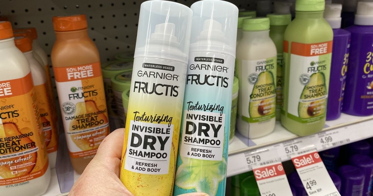 hand holding 2 Garnier Fructis Dry Shampoo in store